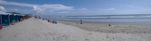 Vista de la playa de Canoa, en Manabí, con mar, arena y acantilados al fondo.
